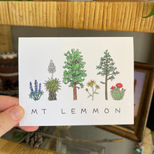 Load image into Gallery viewer, Hand holding a notecard with watercolor illustrations of plants and text that says &quot;Mt Lemmon&quot; in handwritten letters