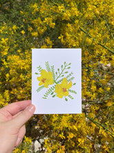 Load image into Gallery viewer, Hand holding a palo verde bloom greeting card next to a real palo verde tree in bloom showing how similar the artwork looks to the real flower