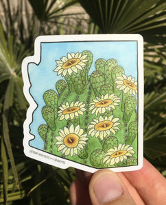 Vinyl sticker in the shape of Arizona with a watercolor painting of the top of a saguaro cactus with white blooming flowers.